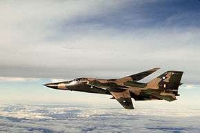 Side view of camouflaged swept-wing military jet in flight