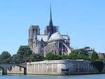 The Seine River flows around an island with a gray stone gothic cathedral rising above the island.