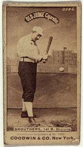 A baseball player is shown holding a baseball bat in the act of hitting a baseball