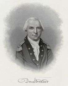 Black and white portrait shows a white-haired man in a dark military coat with darker lapels and a white shirt.