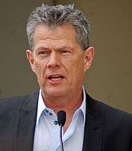 David Foster speaking in front of a microphone