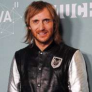 David Guetta is smiling towards the camera.