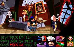 A horizontal rectangular video game screenshot that is a digital representation of domestic room. Four characters stand around a table in the middle of the room. A list of words and icons are below the scene.