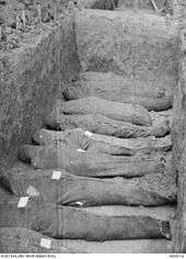 The bodies of nine soldiers wrapped in hessian, laid out in the bottom of a mass grave