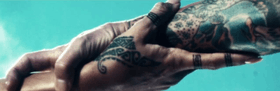 A screenshot of two tattooed hands intertwining