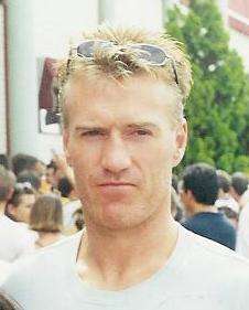 A middle-aged man with blonde hair wearing a gray shirt