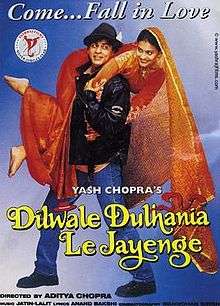 The Dilwale Dulhania Le Jayenge theatrical release poster shows a man in a black leather jacket and blue jeans holding over his shoulders a woman in a red wedding dress. A caption on top reads "Come ... Fall in Love".