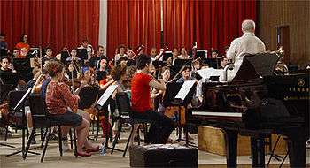 Photo of an orchestra playing in casual dress.