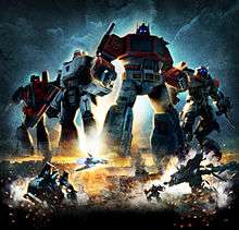 Poster showing Generation 1 (G1) Optimus Prime, G1 Megatron, G1 Starscream, and movie versions of Sideswipe, Jetfire and Soundwave. Four robots are oversized for the poster, and are shown over an Egyptian city.  Below Soundwave is shown in both robot and vehicle modes on the left, while Jazz and Jetfire are shown in robot mode on the right.