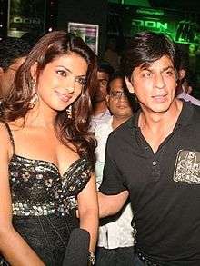 Shah Rukh Khan standing beside Priyanka Chopra at film premiere