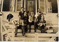 1937 B&W photograph of Donn Reynolds (top left) as "The Yodeling Ranger" seated on steps with his band (Winnipeg, Manitoba, Canada).