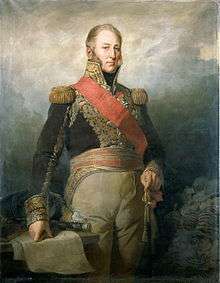 Painting shows a bareheaded man from head to knees. His right hand rests on a map while his left hand grips his sword. He wears a dark blue military coat with a high collar and gold epaulettes, red sash, and tan breeches.