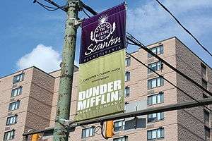 The image is of street banner that reads "Scranton" and Dunder Mifflin".