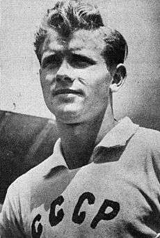 A young man with a ruffled tuft of hair and a white shirt bearing the Cyrillic letters "CCCP".