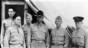 Group portrait of six men in Army uniforms. Lear is conspicuously wearing a campaign hat. Krueger and Eisenhower wear garrison caps.