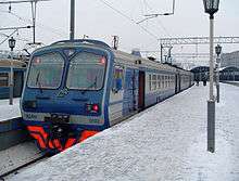 Blue-and-gray passenger train at outdoor station