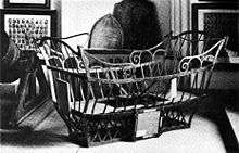 A basket made of iron bars sit among artefacts, such as plaques, portrait collages, and cannon.