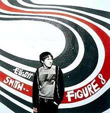A man (Elliott Smith), rendered in black-and-white, stands in front of a wall with a white background and four big swirly lines of paint forming an 'S' shape behind him; the first two are black, the third is red, and the last is black. "Elliott Smith ••" and "Figure 8" are written in white text on the swirls to the left and right sides of the man, respectively.