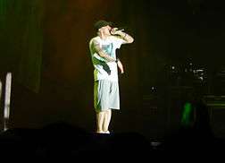 Eminem onstate in T-shirt, shorts and baseball cap