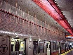 800 slender twelve foot long red neon rods are suspended from wires attached to the ceiling above the subway tracks.