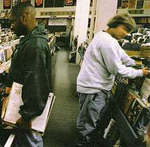 Two men look through vinyl albums at a record store.