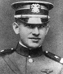 Head of a young man in military uniform with shoulder straps, a high, stiff, collar, and a cap.
