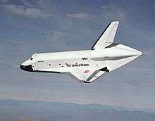 A white space shuttle flies through the atmosphere.