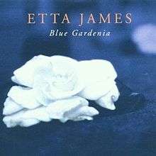 A white gardenia flower with a blue background; above the flower is the text "Etta James" with "Blue Gardenia" below