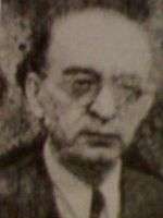 Grainy photo of a bespectacled, balding man