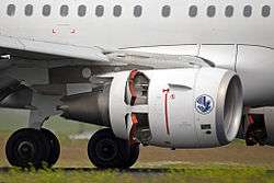 A turbofan engine is shown on an aircraft decelerating on a runway. Small doors on the rear half engine are open.