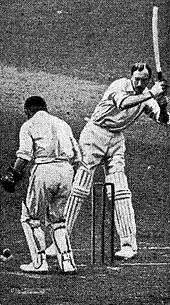 A cricketer trying to hit a ball watched by a wicketkeeper
