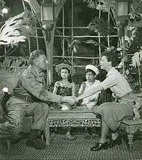 Emile and Nellie grasp hands as Emile's two children look on.