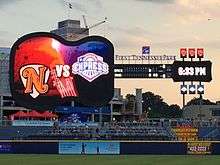 A giant guitar-shaped scoreboard behind the right field fence displays logos for the teams competing in the game, and the game's line score.