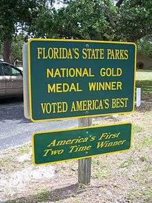 two green signs with yellow border and lettering about Florida State Parks