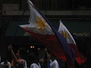 Individuals marching in New York City with Philippine flags.