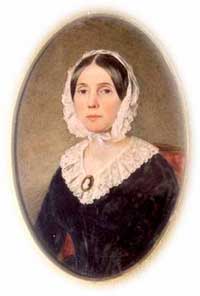 oval of young woman seated, with pinkish white frilled head bonnet and dress top, black narrow waist dress, straight dark hair parted in the middle