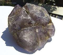 A cluster of purple fluorite crystals with a few crystals of iron pyrite attached.