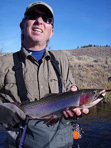 Photo of fisherman holding a rainbow trout