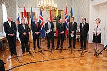 Foreign ministers standing in arc around microphones 2011