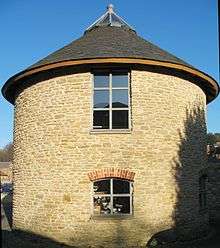 Circular stone building with slate roof.