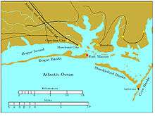 Bogue Banks is a long, narrow island extending from the left edge to past the middle of the chart. Fort Macon is at its eastern end. About two miles to the southeast is the western end of Shackleford Banks, which extends to the east southeast about seven miles. It is separated by a narrow inlet from Core Banks, which extends off the chart to the northeast. Behind these banks are the sounds, ranging in width from one to five miles. Carolina City, Morehead City, and Beaufort are sited on the sounds, all within 10 miles of Fort Macon. The Atlantic and North Carolina Railroad begins in Morehead City and runs off the map to the northwest.
