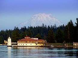 A building on the north shore of Tanglewood Island with Mount Rainier in the distance behind it.