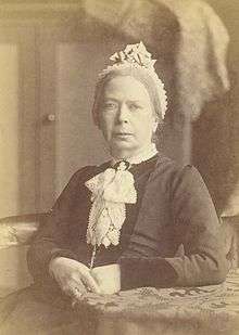 sepia photograph of a seated woman in conservative Victorian dress