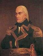 Painting of a man with black eyebrows and white hair pulled back in a queue. He wears a dark blue military uniform and has his right hand stuck between the buttons in Napoleon-style.