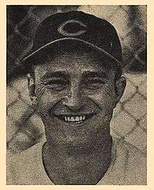 A smiling man in a dark baseball cap with a "C" on the center.