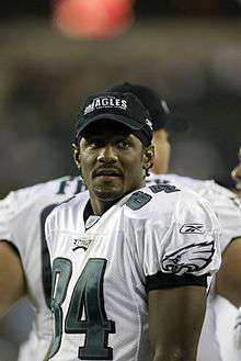 Mitchell standing on the sidelines during a preseason game with an Eagles cap on.
