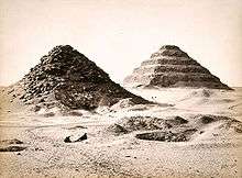 Two pyramids engulfed by the desert sand.