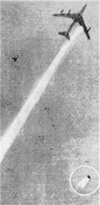 A photograph of an aircraft in flight, with an engine falling to earth