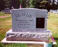 A marble gravestone engraved "GG Allin: For my mission ends in termination, vicinity of death. Live fast die; 8-29-1956 – 6-28-1993"