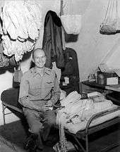  Halvorsen sitting on cot in barracks surrounded by handkerchiefs to be made into parachutes